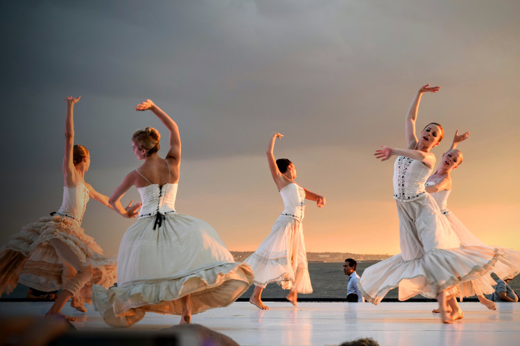 5 women in white dress dancing in a performance