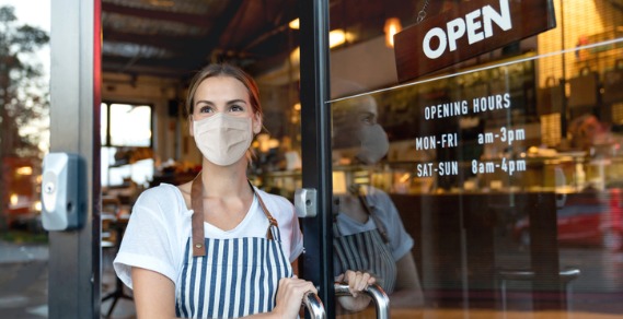 Waitress wearing a mask outside a cafe
