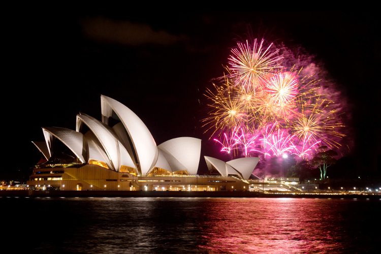 A photograph of the Sydney Opera House Sails overlooking the Harbour with fireworks in the night sky.