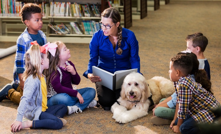 children in library with reading assistance dog picture