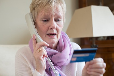 Elderly woman on phone call and holding credit card