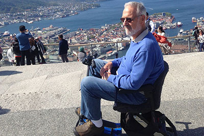 Man sitting in mobility scooter overlooking a beautiful ocean vista