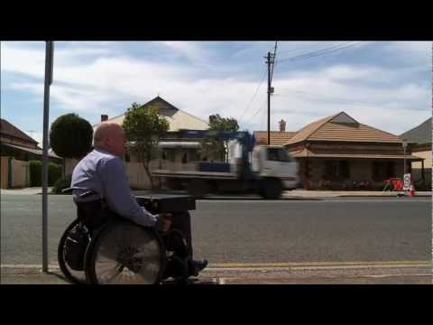 Man sitting on the side of the road in a wheelchair
