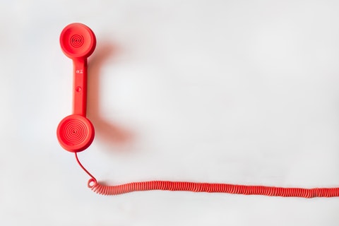 red phone handset with spiral chord