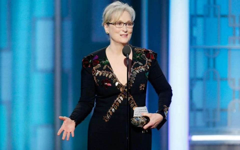 Actor Meryl Streep stands at a podium on stage at the Oscars