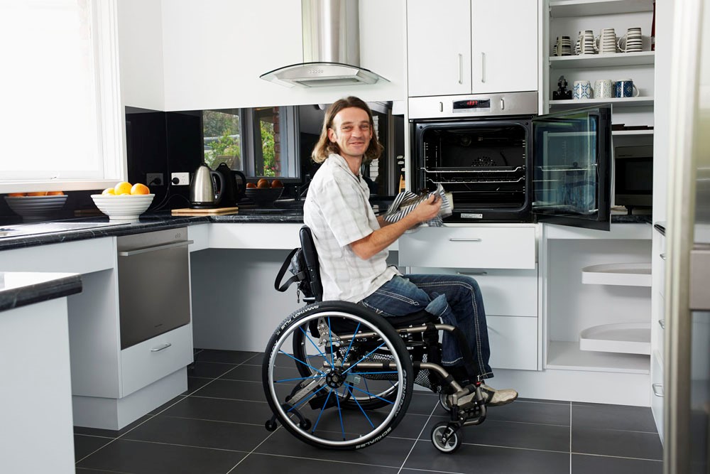 Modified kitchen that includes accessible appliances and wheelchair accessible worktops. 