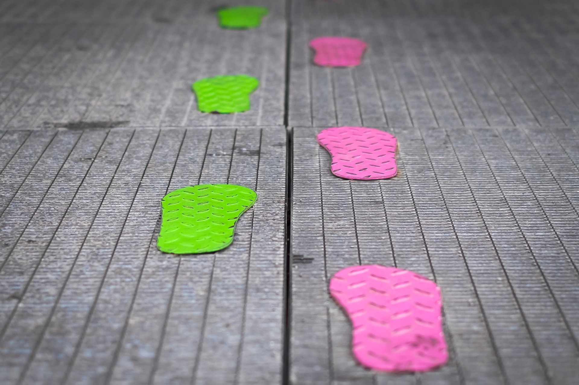Image displays pink and green coloured footsteps depicting taking steps